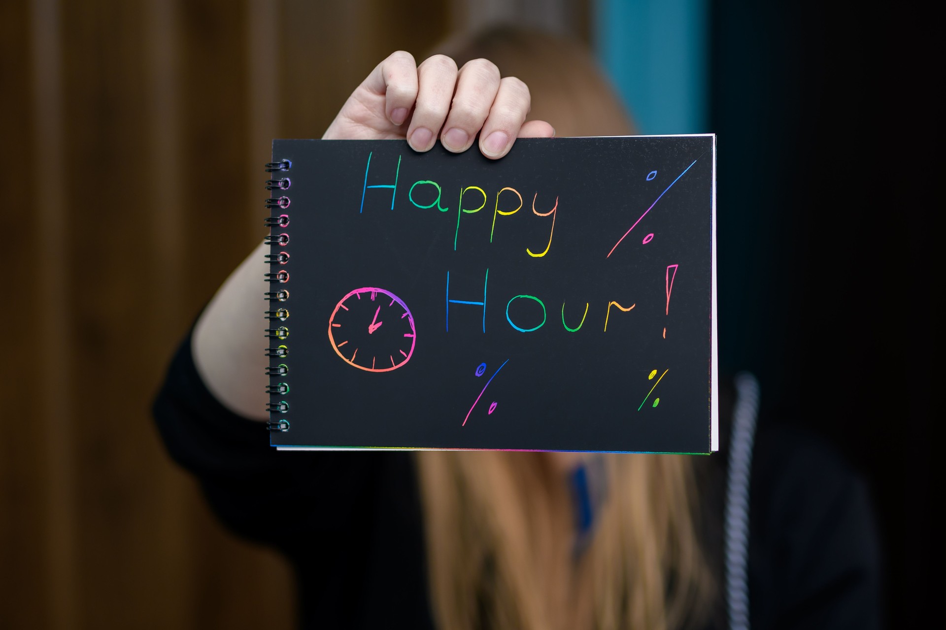 A woman holds an advertisement for happy hour in her hands, an inscription on a piece of paper